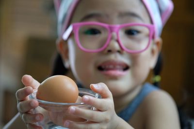 Close-up portrait of girl holding egg