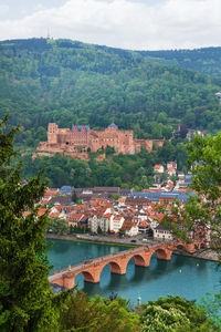 Arch bridge over river amidst buildings against sky