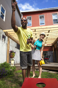 Couple playing bean bag toss game in lawn