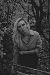 Portrait of young woman standing in forest