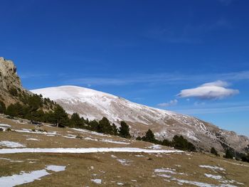 Scenic view of snowcapped mountains against blue sky