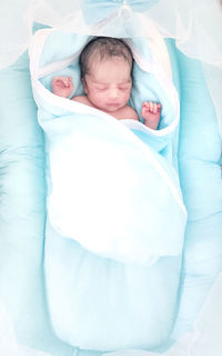 Portrait of cute baby boy sleeping on bed