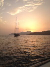 Sailboat sailing in sea at sunset