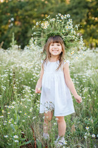 Portrait of a smiling girl standing on field