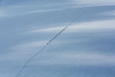 High angle view of people walking in row on snow during winter