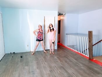 Young women standing against wall