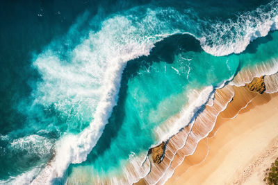 Aerial view of sandy beach and ocean nature with waves.