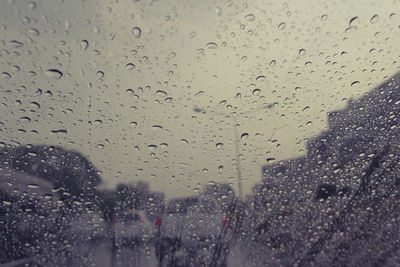 Raindrops on windshield seen through wet window