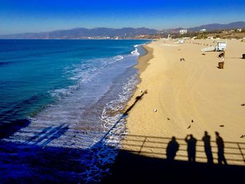 Scenic view of beach against clear blue sky