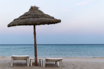 Chair on beach against sky