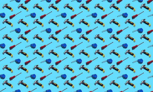 Hammers, screwdrivers and measuring tape on a blue background, pattern, hard shadows. 