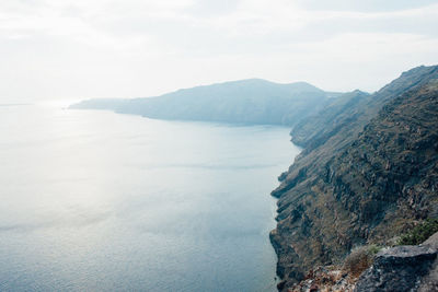 Scenic view of sea and mountains against sky