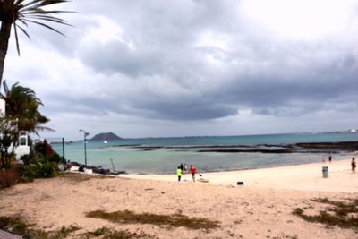 People on beach against sky