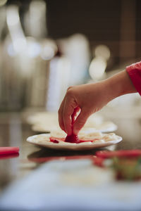 Midsection of woman eating food in kitchen