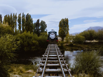 Train on railroad track amidst trees against sky