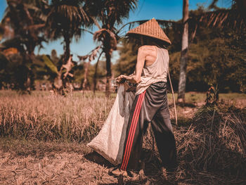 Full length of woman wearing hat on field