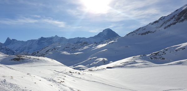 Scenic view of snow covered mountains against sky