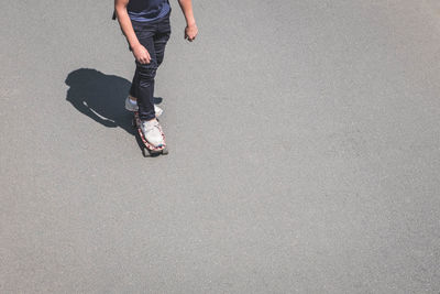 Low section of man skateboarding on road