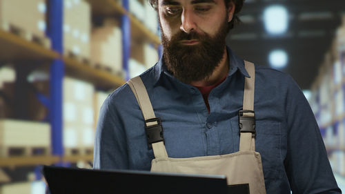 Portrait of young man using laptop while sitting in office