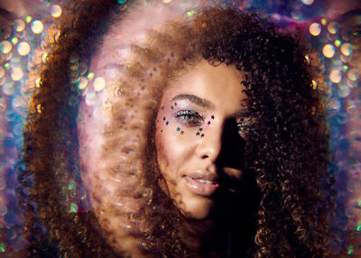 Portrait of young woman with make-up and brown curly hair