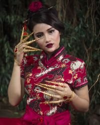 Portrait of young woman holding red mask