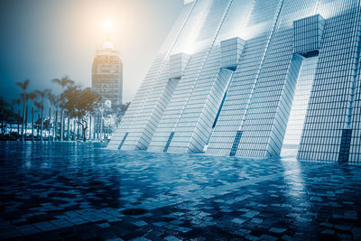 Modern buildings by swimming pool in city against sky