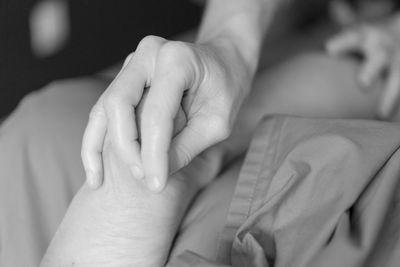 Cropped hands of masseur massaging customer in spa