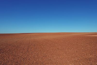 Scenic view of desert against clear blue sky