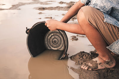 Low section of woman sitting on beach