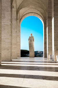 View of statue with historical building against sky