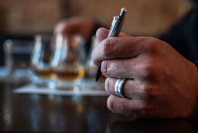 Close-up of hand holding pen at table