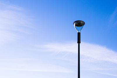 Low angle view of street light against blue sky