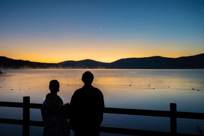 People are watching the lake air raise during sunrise.