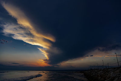 Scenic view of sea against dramatic sky during sunset