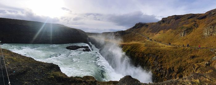 Scenic view of waterfall against sky