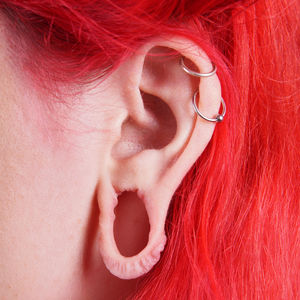 Cropped image of woman with pierced ear and dyed hair