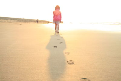 Rear view of woman walking on beach