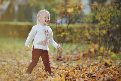 Playful girl standing on field during autumn