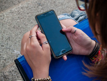 Midsection of woman using mobile phone outdoors