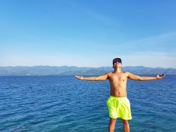 Portrait of smiling girl on beach against clear blue sky