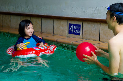 Man with daughter in swimming pool