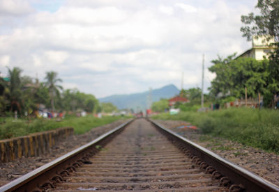 Railroad track against cloudy sky