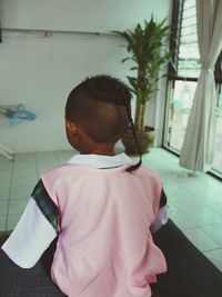 Rear view of girl standing at home