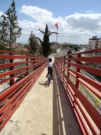 Man riding bicycle on road against sky