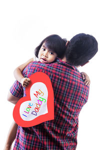 Mother and daughter standing against white background