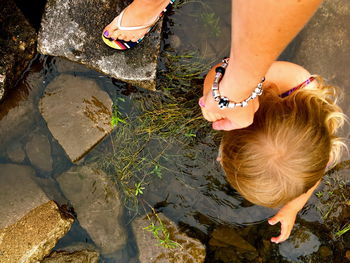 High angle view of woman holding girl by water