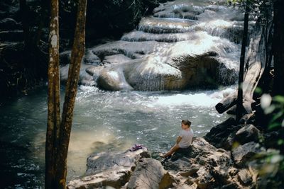 Man standing by rocks in water