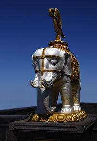 Low angle view of statue against blue sky