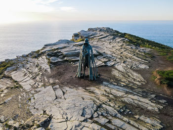 Monument to king arthur on a rock against the backdrop of the ocean