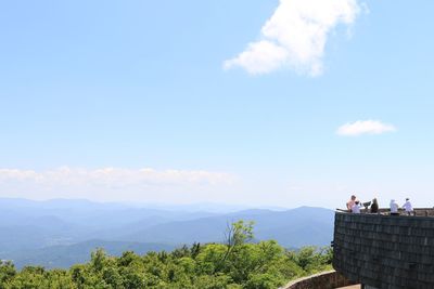 People on mountain against sky